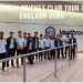 A group of young cricket players in matching Mumbai Cricket Club (MCC) uniforms standing together at Heathrow Airport, posing for a team photo near a wall with the Heathrow logo.